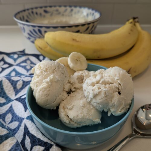 a bowl of ice cream next to bananas