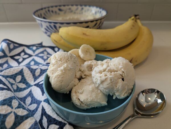 a bowl of ice cream next to bananas