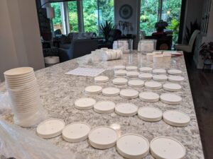 Lids for the chocolate ice cream taste test containers, in rows on a counter